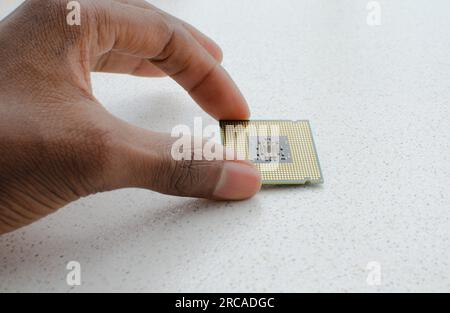 Mano ferma con un processore ad alte prestazioni, simbolo dell'evoluzione e del progresso tecnologico. Foto Stock