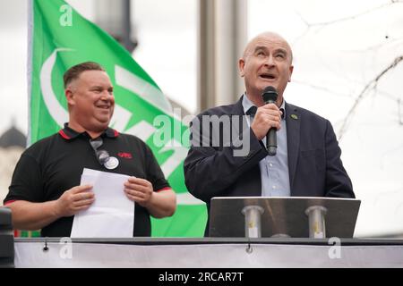 Rail, Maritime and Transport (RMT) il segretario generale dell'unione Mick Lynch parla a una manifestazione mentre Alex Gordon presidente dell'RMT (a sinistra) ascolta fuori dalla stazione di King's Cross, a Londra, La scorsa settimana l'ente di trasporto ferroviario (RDG) ha presentato proposte per una chiusura di massa delle biglietterie delle stazioni ferroviarie in Inghilterra. Data foto: Giovedì 13 luglio 2023. Foto Stock