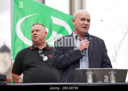 Rail, Maritime and Transport (RMT) il segretario generale dell'unione Mick Lynch parla a una manifestazione mentre Alex Gordon presidente dell'RMT (a sinistra) ascolta fuori dalla stazione di King's Cross, a Londra, La scorsa settimana l'ente di trasporto ferroviario (RDG) ha presentato proposte per una chiusura di massa delle biglietterie delle stazioni ferroviarie in Inghilterra. Data foto: Giovedì 13 luglio 2023. Foto Stock