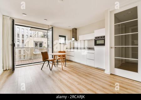 cucina e zona pranzo in un moderno appartamento con porte scorrevoli in vetro che conducono al balcone e al patio esterno Foto Stock