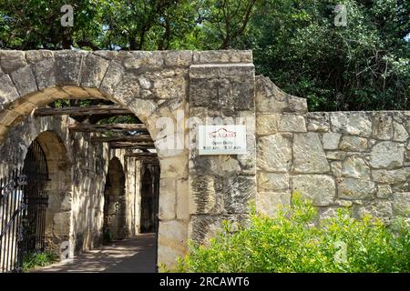 San Antonio, Texas, USA – 8 maggio 2023: Muro di recinzione in pietra con archi presso l'Alamo di San Antonio, Texas. Foto Stock