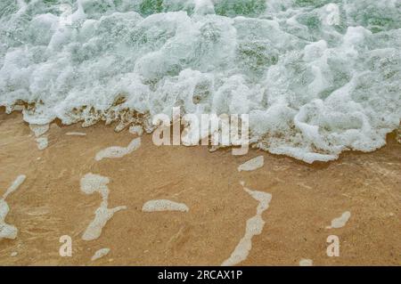 Primo piano delle Waves che si schiantano sulla Sandy Shore, Cornovaglia, Inghilterra, Regno Unito Foto Stock