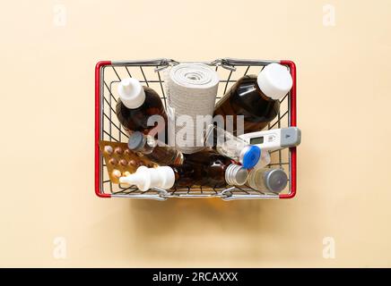 Mini carrello con diversi farmaci su sfondo beige Foto Stock