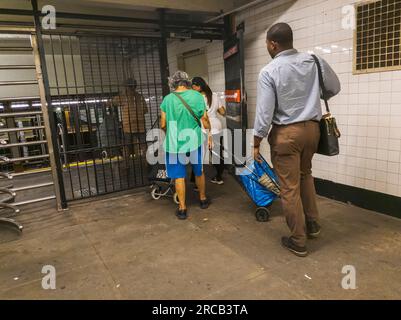 Gli evasori di tariffe entrano coraggiosamente nella West 23rd St Station nella metropolitana di New York attraverso il cancello di uscita di emergenza, evadendo di pagare la tariffa, mercoledì 12 luglio 2023. (© Richard B. Levine) Foto Stock