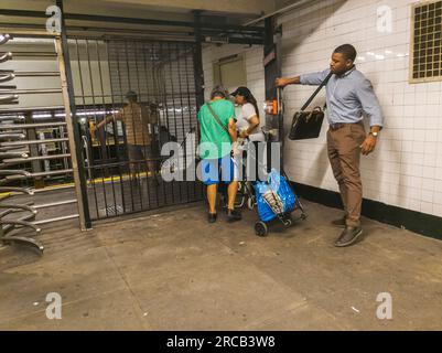 Gli evasori di tariffe entrano coraggiosamente nella West 23rd St Station nella metropolitana di New York attraverso il cancello di uscita di emergenza, evadendo di pagare la tariffa, mercoledì 12 luglio 2023. (© Richard B. Levine) Foto Stock