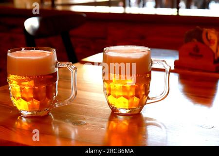 2 bicchieri di birra con schiuma spessa in un ristorante, bar, birreria, Praga, Repubblica Ceca. Vera birra ambrata in tazze, pinta Foto Stock