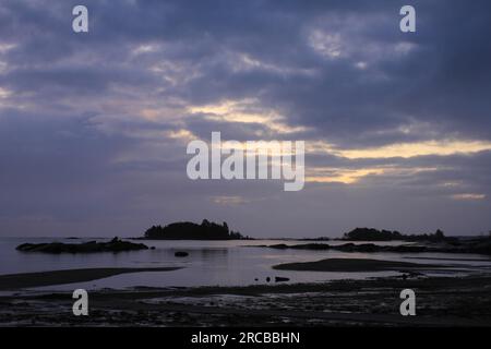 La luce del sole spinge attraverso fitte nuvole mattutine sulle rive del lago di Vanern, Svezia Foto Stock