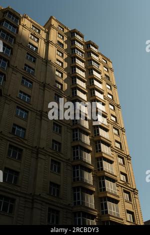 Una cattura ravvicinata di un edificio storico inondato di luce solare a Baku la mattina del 26 giugno 2023. La luce dell'alba crea un meraviglioso textur Foto Stock