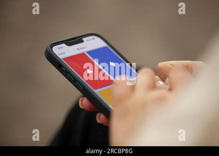 Kahoot! app. Schoolgirl risponde alla domanda del quiz sullo smartphone. Foto Stock