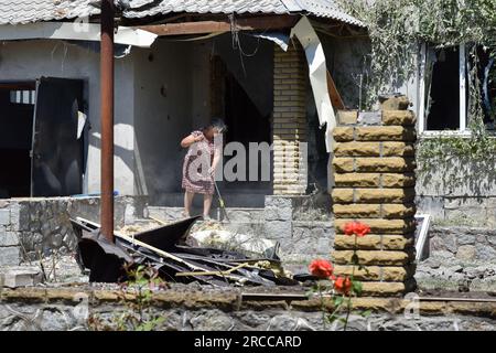 Verkhnya Tersa, Ucraina. 13 luglio 2023. Una donna pulisce un'area di una casa privata danneggiata dai bombardamenti russi nel villaggio di Verkhnya Tersa. Il 505° giorno della guerra russa contro l'Ucraina, sono in corso pesanti combattimenti sui fronti Kupiansk, Lyman, Bakhmut, Avdiivka e Marinka. Sui fronti Zaporizhzhia e Kherson, i russi stanno cercando di impedire alle forze ucraine di avanzare. Credito: SOPA Images Limited/Alamy Live News Foto Stock