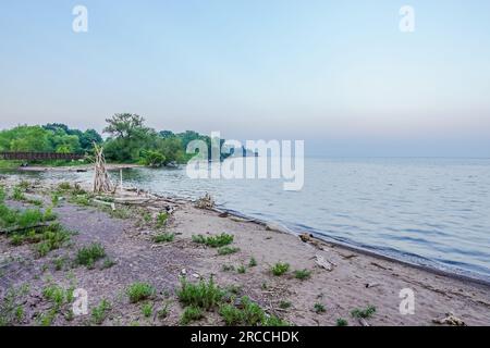 Una spiaggia non mantenuta e di scarsa qualità piena di sabbia grossolana ed erba a Toronto, Canada Foto Stock
