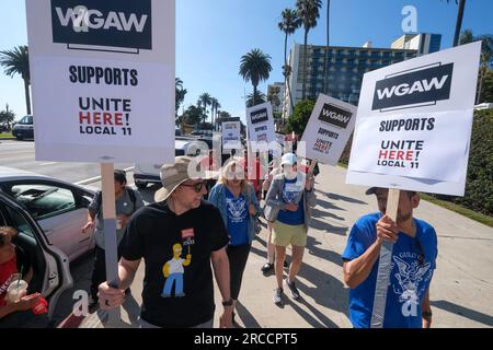 Los Angeles, Stati Uniti. 13 luglio 2023. I membri della Writers Guild of America (WGA) si uniscono alla Writers Guild of America West (WGAW) per sostenere i lavoratori degli hotel in sciopero, UNISCITI QUI! Gli 11 locali, mentre fanno il picchetto all'esterno del Fairmont Miramar Hotel & Bungalows a Santa Monica. (Foto di Ringo Chiu/SOPA Images/Sipa USA) credito: SIPA USA/Alamy Live News Foto Stock