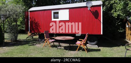 un rimorchio rosso con sedie e un tavolo Foto Stock