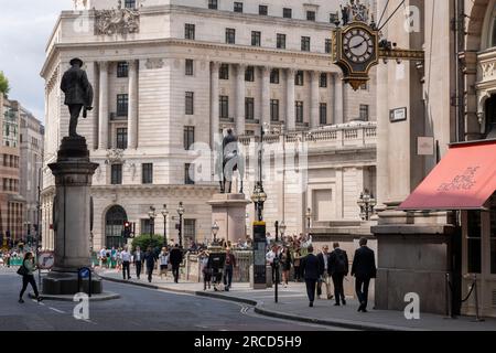 Una veduta su Cornhill, dove la statua dell'ingegnere James Henry Greathead si erge sopra i membri del pubblico nella City di Londra, il quartiere finanziario della capitale, il 13 luglio 2023, a Londra, in Inghilterra. L'ingegnere civile James Henry Greathead (1844-1896), è famoso per il suo lavoro sulla metropolitana di Londra. Foto Stock