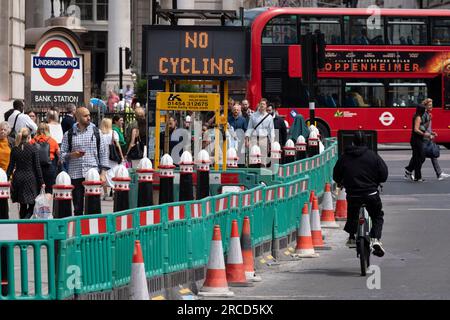 Un ciclista passa un cartello a matrice che dice ai ciclisti di non pedalare sulla strada verso Threadneedle Street e Cornhill a causa del traffico in arrivo, nella City of London, il quartiere finanziario della capitale, il 13 luglio 2023, a Londra, in Inghilterra. Foto Stock