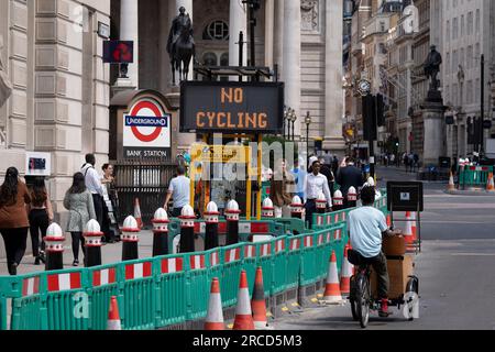 Un ciclista passa un cartello a matrice che dice ai ciclisti di non pedalare sulla strada verso Threadneedle Street e Cornhill a causa del traffico in arrivo, nella City of London, il quartiere finanziario della capitale, il 13 luglio 2023, a Londra, in Inghilterra. Foto Stock