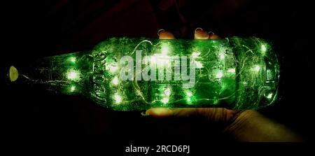 Bottiglia di luce verde brillante a tuni su sfondo nero Foto Stock