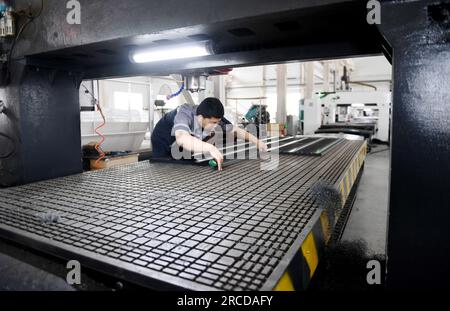 ZHANGJIAKOU, CINA - 14 LUGLIO 2023 - un dipendente di Zhangjiakou Kono Engineering Plastics Co., Ltd. Lavora su una linea di produzione a di lastre di ghiaccio artificiali Foto Stock