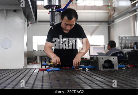 ZHANGJIAKOU, CINA - 14 LUGLIO 2023 - un dipendente di Zhangjiakou Kono Engineering Plastics Co., Ltd. Lavora su una linea di produzione a di lastre di ghiaccio artificiali Foto Stock