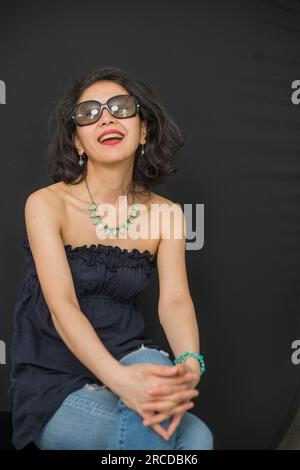 La donna giapponese pensa mentre è seduta in studio Foto Stock
