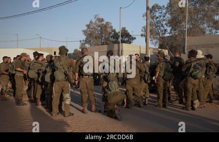 I soldati israeliani stanno insieme in un quartiere residenziale simulato prima di una sessione di addestramento all'interno del Centro di addestramento per la guerra urbana di Tze'elim dell'esercito israeliano il 12 luglio 2023 nel deserto del Negev, in Israele. Il TSE'elim Urban Warfare Training Center soprannominato "Baladia" (in arabo per "distretto") è un modello di un villaggio medio-orientale generico costruito e finanziato in gran parte tramite aiuti militari statunitensi, per l'addestramento delle unità di combattimento, ed è costituito da una città in stile arabo. Foto Stock