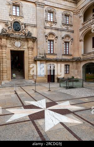 Mdina, Malta, 30 aprile 2023. Croce maltese sul terreno di fronte al Palazzo di Vilhena, Museo Nazionale di Scienze naturali. Foto Stock