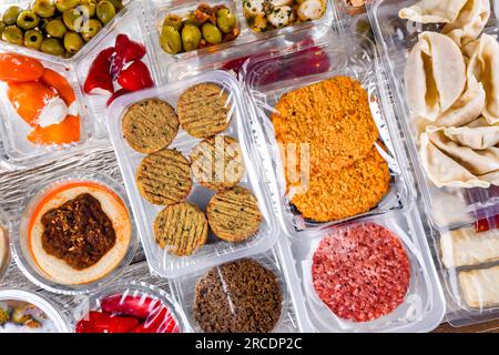 Esposizione di una varietà di prodotti alimentari preconfezionati in scatole di plastica. Foto Stock