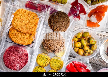 Esposizione di una varietà di prodotti alimentari preconfezionati in scatole di plastica. Foto Stock