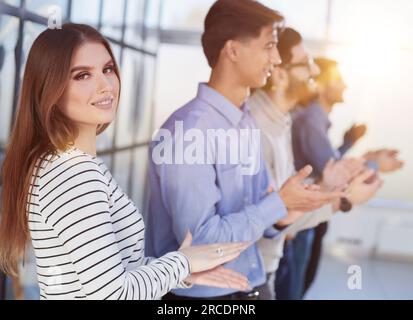 Primo piano profilo laterale, diversi partecipanti uomini d'affari stand ed esprimere apprezzamento battendo le mani Foto Stock