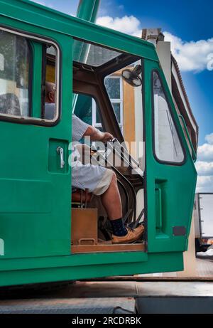 lavoratore africano in una cabina di gru verde che usa i lasciapassare Foto Stock