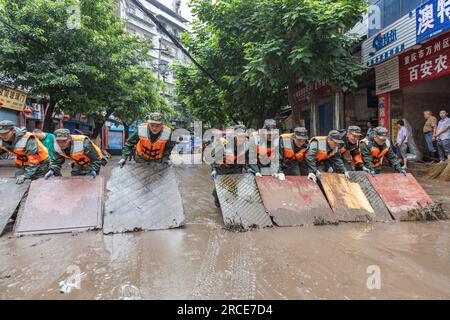 (230714) -- WANZHOU, 14 luglio 2023 (Xinhua) -- i soccorritori puliscono una strada allagata nel distretto di Wanzhou, municipalità di Chongqing della Cina sud-occidentale, 14 luglio 2023. Le precipitazioni hanno colpito 28 distretti e contee di Chongqing da giovedì, con una piovosità massima giornaliera record di 227 mm registrata nel distretto di Wanzhou, secondo il servizio meteorologico locale. La forte pioggia ha gonfiato 44 fiumi a Wanzhou di 1-4 metri, ha detto l'ufficio di gestione delle emergenze del distretto. I giornalisti del sito hanno detto che molte strade basse sono state sommerse in acque alluvionali profonde fino a 1,5 metri. (Xin Foto Stock