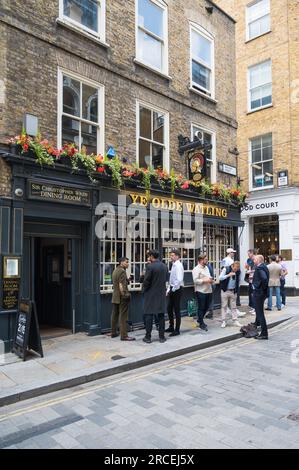 La gente è fuori e fuori all'ora di pranzo. Gruppi di uomini che si alzano e bevono fuori dal pub Ye Olde Watling. Watling Street, City of London, Inghilterra Regno Unito Foto Stock