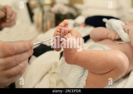 Unzione con olio in battesimo con le mani del sacerdote. Foto Stock