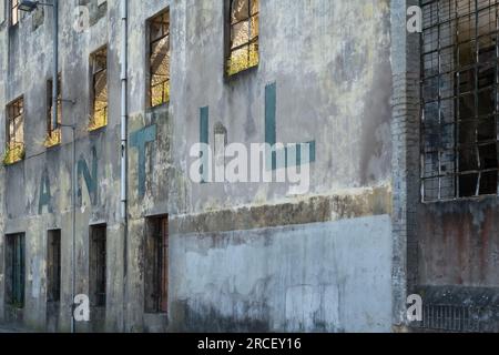 Porto, Portogallo - 25 aprile 2023: Dettaglio architettonico della facciata a più piani di un edificio abbandonato con infissi e porte Foto Stock