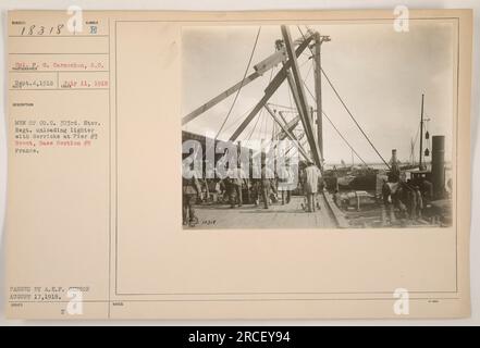 Uomini della compagnia C del 303° Stov. Il reggimento viene visto scaricare un accendino con l'aiuto di derrick al molo n. 3 a Brest, sezione base n. 5, Francia. Questa foto è stata scattata il 4 settembre 1918 ed è stata approvata dalla censura A.E.F. il 17 agosto 1918. Didascalia: 'Uomini della compagnia C che scaricano accendini con derrick al molo n. 3, Brest, Francia.' Foto Stock