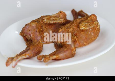 Carne di quaglia marinata. Carne di quaglia marinata con peperoncino rosso in polvere, pepe, pasta di aglio allo zenzero, sale e succo di lime prima della frittura. Quail Meet è c Foto Stock