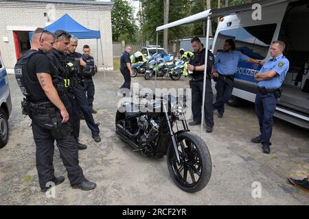 Teltow, Germania. 14 luglio 2023. Gli agenti di polizia controllano una motocicletta. Gli agenti di polizia dell'accademia di polizia e circa 100 partecipanti provenienti da 14 stati federali e tre nazioni hanno preso parte al controllo del traffico nel distretto di Teltow-Fläming, che è stato esercitato in connessione con un vicino incontro motociclistico. Ciò includeva anche un'operazione pratica congiunta nel contesto di un controllo del traffico nel distretto di Teltow-Fläming. Credito: Michael Bahlo/dpa/Alamy Live News Foto Stock