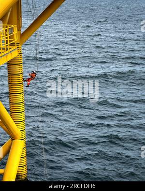 Lavoratore del Mare del Nord, accesso con corda IRATA, arrampicata. Piattaforma petrolifera. Sottostazione del parco eolico. Foto Stock