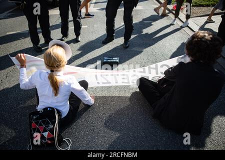 AM 14. Juli 2023, blockierten Aktivist*innen der letzten Generation am Stachus in München, Deutschland. Einige klebten sich fest und einer betonierte sich an die Straße fest. Die Letzte Generation fordert ein Tempolimit von 100 km/h auf Autobahnen, Die Einführung eines Neun-Euro-Tickets und einen Gesellschaftsrat Klima. -- il 14 luglio 2023, attivisti dell'ultima generazione si sono bloccati allo Stachus, a Monaco, in Germania. Alcuni si sono bloccati e uno si è concretizzato in strada. L'ultima generazione richiede un limite di velocità di 100 km/h sulle autostrade, l'introduzione di un biglietto da nove euro e di un soc Foto Stock