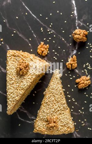 Torta di noci e semi di papavero. Fette di torta su sfondo scuro. Vista dall'alto Foto Stock