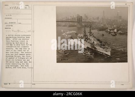 Una nave da battaglia statunitense, la USS Pennsylvania (BB-38), si avvicina al Brooklyn Navy Yard a New York. La nave sta andando in cantiere per essere esaminata e riparata dopo aver prestato servizio in mare. È appena passato sotto l'iconico Ponte di Brooklyn, che collega i due quartieri della città. Lo skyline sullo sfondo è quello della parte bassa di New York. La fotografia è stata scattata nel 1919 da un fotografo sconosciuto e fa parte delle fotografie delle attività militari americane durante la prima guerra mondiale. Foto Stock