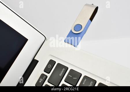 Fusione tra dispositivi: pendrive e notebook si fondono in un'immagine che trasmette innovazione ed efficienza. Foto Stock