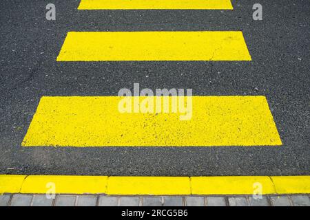 Strisce incrociate gialle zebre dipinte sulla strada. Foto Stock