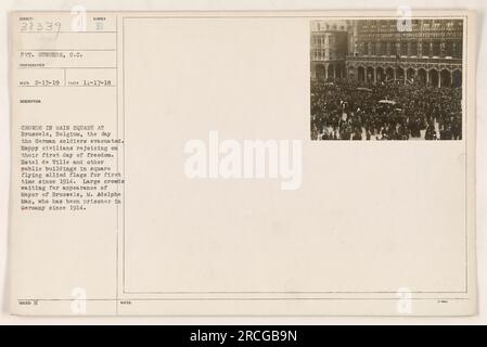 Pvt. Gunshor ha scattato questa foto il 17 novembre 1918 a Bruxelles, in Belgio. L'immagine mostra grandi folle nella piazza principale, nota come Slingen, che celebra il giorno in cui i soldati tedeschi evacuarono la città. I civili, pieni di gioia nel loro primo giorno di libertà, sono visti rallegrarsi e circondati da edifici adornati con bandiere alleate. La folla attende con impazienza la comparsa del sindaco M. Adolphe Max, che era stato tenuto prigioniero in Germania dal 1914. Foto Stock