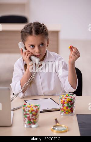 Bambina che gioca a fare il medico nel concetto di telemedicina Foto Stock