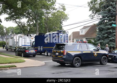 New York, USA. 14 luglio 2023. MASSAPEQUA PARK, NEW YORK - 14 LUGLIO: I funzionari delle forze dell'ordine sono visti mentre indagano sulla casa di un sospettato arrestato nell'irrisolto omicidio di Gilgo Beach il 14 luglio 2023 a Massapequa Park, New York. Un sospettato degli omicidi di Gilgo Beach è stato arrestato nel caso irrisolto legato ad almeno 10 serie di resti umani scoperti dal 2010 nella periferia di Long Island. Il sospetto Rex Heuermann dovrebbe essere denunciato dopo il suo arresto giovedì sera. Un gran giurì accusò Heurmann di sei capi d'accusa per omicidio. Credito: Storms Media Group/Alamy Live News Foto Stock