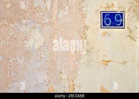 Numero 69, sessantanove, su una superficie di parete con vernice intemprata. Foto Stock