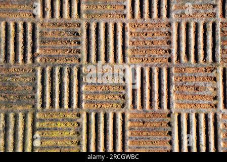 sfondo industriale di un coperchio del pozzetto arrugginito Foto Stock