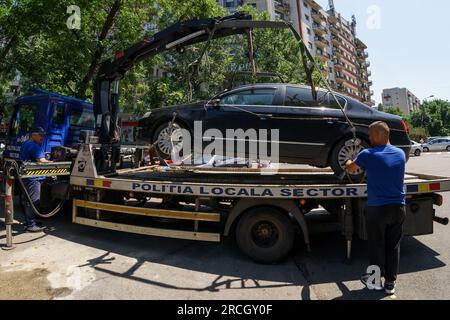 Bucarest, Romania. 14 luglio 2023: La polizia locale del settore 4 solleva un'auto parcheggiata illegalmente su un autocarro durante l'inaugurazione del mercato agroalimentare 'Piata Norilor' da parte del Municipio del settore 4, Bucarest. Piața Norilor, il più nuovo e uno dei più moderni della capitale, è stato ricostruito nel suo vecchio sito dopo che il vecchio mercato a un piano è stato demolito e ora ha due piani, Al piano terra si trova un parcheggio e al primo piano si trova il mercato agroalimentare rivolto agli agricoltori rumeni. Crediti: Lucian Alecu/Alamy Live News Foto Stock