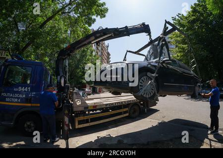 Bucarest, Romania. 14 luglio 2023: La polizia locale del settore 4 solleva un'auto parcheggiata illegalmente su un autocarro durante l'inaugurazione del mercato agroalimentare 'Piata Norilor' da parte del Municipio del settore 4, Bucarest. Piața Norilor, il più nuovo e uno dei più moderni della capitale, è stato ricostruito nel suo vecchio sito dopo che il vecchio mercato a un piano è stato demolito e ora ha due piani, Al piano terra si trova un parcheggio e al primo piano si trova il mercato agroalimentare rivolto agli agricoltori rumeni. Crediti: Lucian Alecu/Alamy Live News Foto Stock